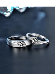Macro shot of S925 silver moissanite couple rings with 3EX cut on blue background