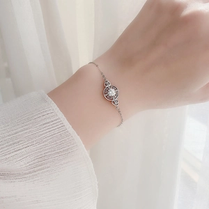 Elegant 925 sterling silver bracelet with moissanite coin pendant and fine chain on wrist