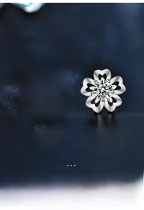 Detailed macro view of S925 silver cherry blossom stud earrings with moissanite center