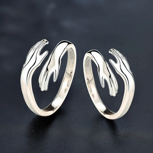 Detail of S925 sterling silver hug rings showing the palm-shaped clasp and hallmark