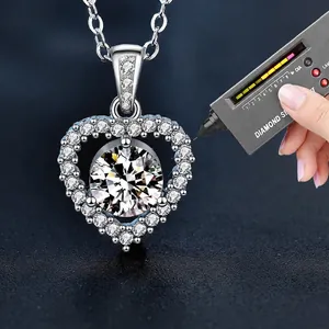 925 silver heart necklace with moissanite pendant on a dark blue velvet display stand