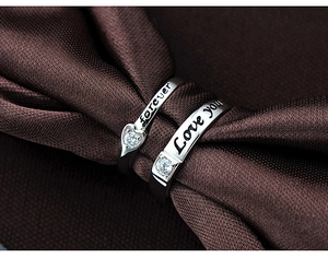 Vue macro de bagues de couple en argent 925 avec forme de cœur et gravure Love You