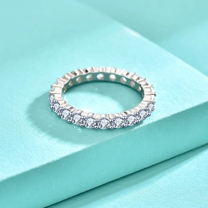 Macro view of 925 sterling silver eternity ring with zircon stones on a blue podium