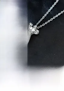 Detailed close-up of S925 sterling silver crown pendant with a dancing moissanite stone