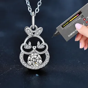 Moissanite rabbit necklace in 925 sterling silver being tested for quality with a diamond pen