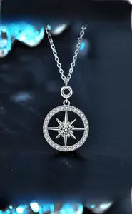 Close-up of 925 sterling silver star pendant with 3EX cut moissanite on black background