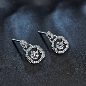 Detailed macro view of geometric Moissanite silver stud earrings with diamond pavé border