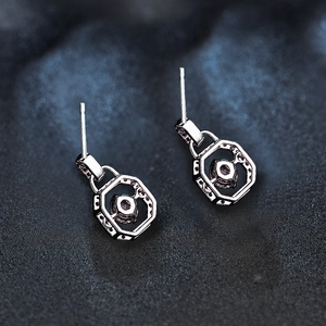 Macro view of geometric hexagonal stud earrings with sparkling center diamond stones