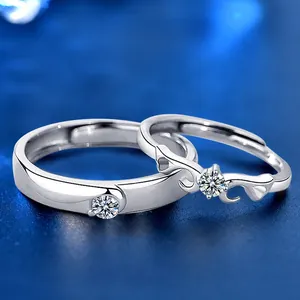 Macro detail of silver angel wing couple rings with round cut moissanite stones