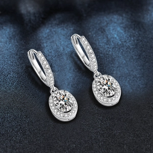 Macro detail of oval moissanite drop earrings in 925 sterling silver with halo setting
