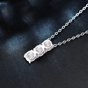 Detailed view of sterling silver necklace with three vertical moissanite stones