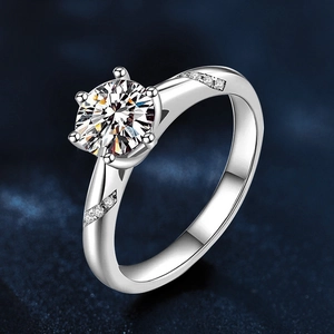 Detailed close-up of six-prong moissanite ring with side accent diamonds on silver band