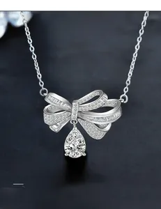Macro shot of 925 silver bow pendant with pear cut moissanite and sparkling stones