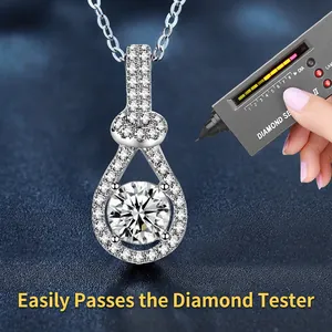 Sterling silver teardrop moissanite necklace with round cut diamond being tested