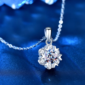 Detailed macro view of silver snowflake pendant with moissanite main stone and heart-shaped prongs