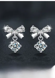 Macro detail of S925 sterling silver bow earrings featuring sparkling moissanite stones