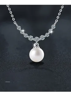 Détail macro du collier en argent S925 avec perle et pendentif sourire en moissanite