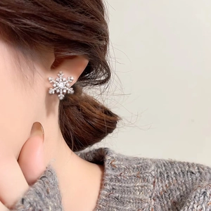 Elegant S925 sterling silver snowflake stud earrings with moissanite stones on model