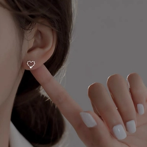 Elegant s925 silver hollow heart stud earrings with moissanite pavé on a female model