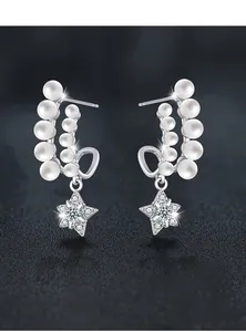 Detail of star-shaped earrings with double row pearls and sparkling cubic zirconia stones
