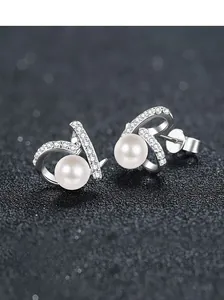 Macro detail of S925 sterling silver earrings with freshwater pearls and moissanite accents