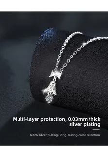Macro detail of silver bow and bell pendant showing multilayer nano plating craftsmanship