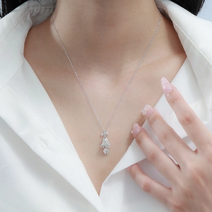 Elegant S925 silver bell necklace with bow pendant on model wearing white shirt