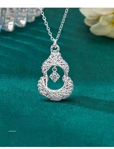 Macro shot of S925 silver gourd pendant with brilliant-cut moissanite on green velvet
