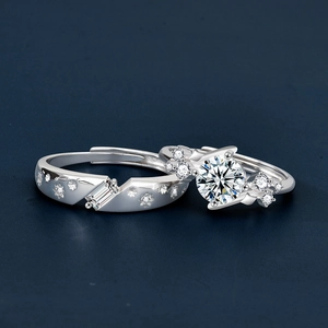 S925 sterling silver couple rings with moissanite accents on dark blue background