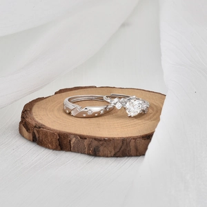 Elegant S925 sterling silver moissanite couple rings set on natural wood background
