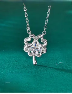 Macro detail of S925 silver clover pendant with 3EX cut moissanite on green velvet