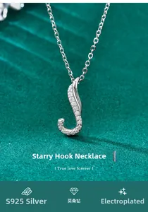 Macro detail of S925 sterling silver hook pendant with moissanite pavé on green velvet