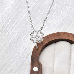 S925 sterling silver four-leaf clover pendant necklace with moissanite on silk background