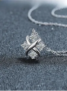 Dettaglio macro della collana con ciondolo X in argento con moissanite e placcatura