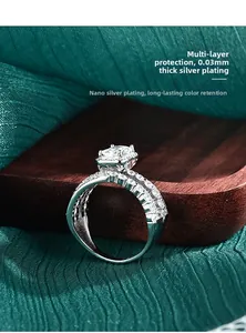 Macro shot of silver ring with emerald cut moissanite on silk and wood tray