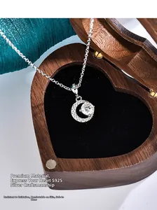 Macro detail of S925 sterling silver moon necklace with moissanite in a wooden box