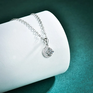 Elegant S925 sterling silver moon and star necklace with moissanite on a green pedestal