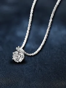 Macro detail of S925 sterling silver six-prong moissanite crown pendant on a shiny chain