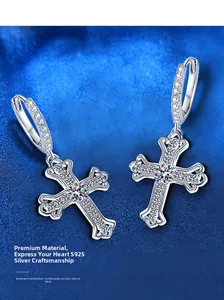 Macro shot of S925 silver cross drop earrings with pavé-set moissanite on blue background