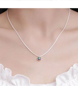 Close-up of sparkling moissanite crown necklace on neck with iridescent gemstone detail