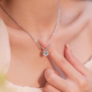 Sparkling crown six-prong moissanite necklace on model with elegant sterling silver chain
