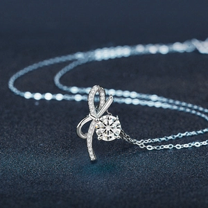 S925 sterling silver bow pendant necklace with sparkling moissanite on a dark background