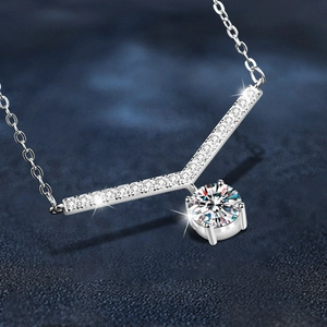 Collier en argent 925 avec pendentif en V et moissanite sur un élégant fond bleu foncé