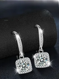 Macro shot of S925 sterling silver square moissanite drop earrings on black texture