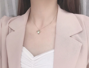 Close-up of golden bee pendant with moonstone on a delicate silver chain
