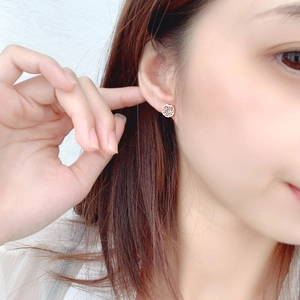 Elegant Christmas wreath stud earrings with red and green stones on a model