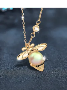 Macro view of S925 sterling silver bee pendant with iridescent pearl and black diamonds