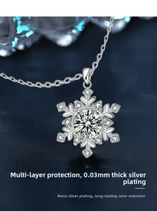 Macro du pendentif flocon en argent 925 avec moissanite sur socle bleu foncé