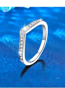 Macro shot of V-shaped sterling silver ring with cubic zirconia on blue background