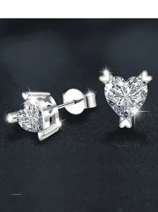 Detail of heart-shaped S925 sterling silver studs with moissanite on rock texture